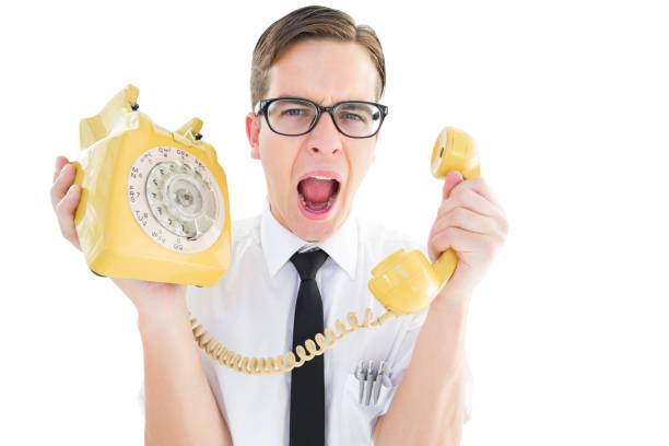 istock Geeky businessman shouting at retro phone 818073398