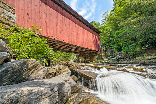 Built in 1887, the historic Packsaddle Covered Bridge crosses over a waterfall on Brush Creek in rural Somerset County, Pennsylvania.