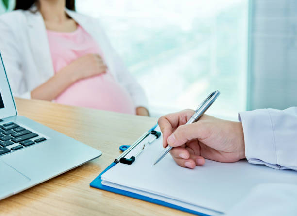 istock Doctor writing notes for pregnant woman 818078392