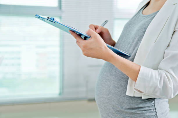 istock Pregnant woman writing in binder 818087772