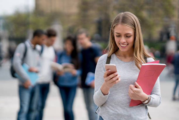 istock Female student texting on her mobile phone outdoors 818088118