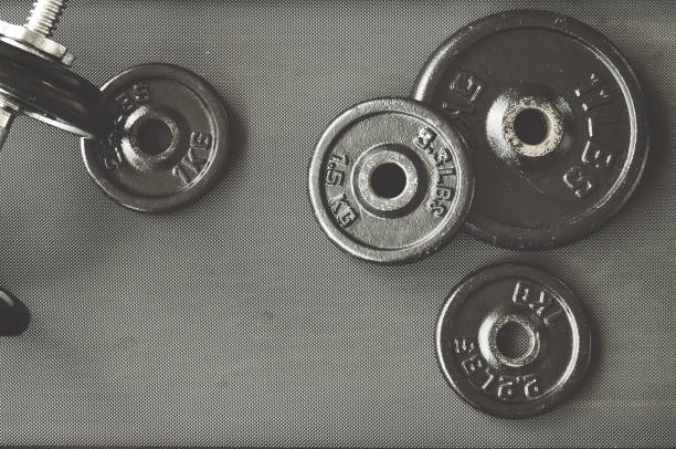 istock dumbbell and barbell on floor at gym 818090338