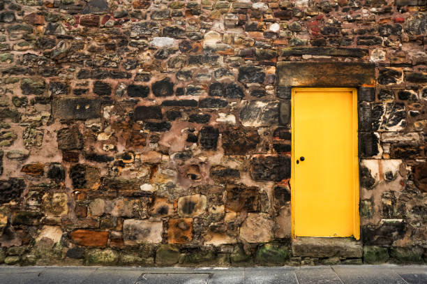 A bright yellow door and a stone exterior in St. Andrews, Scotland, United Kingdom