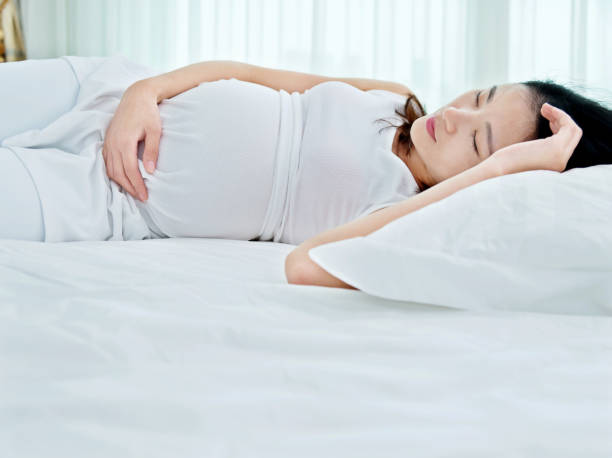 istock Pregnant woman sleeping in bed 818130544