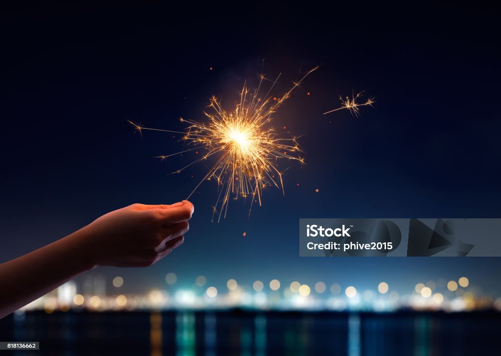 Female hand holding a burning sparkler Sparkler - Firework Stock Photo