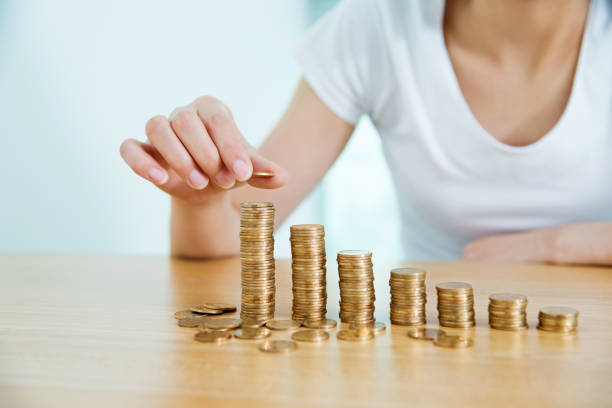 istock Woman putting a coin on stack of currency 818136794