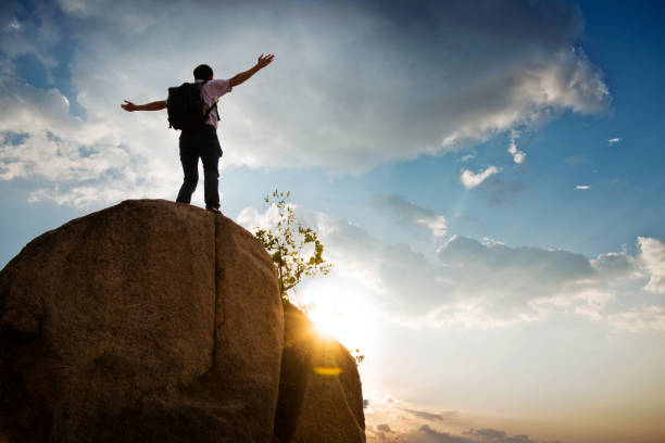 istock Man at mountain top with arms outstretched 818163678
