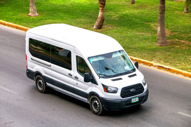 Ford Transit CANCUN, MEXICO - JUNE 3, 2017: White van Ford Transit in the city street. bus livery stock pictures, royalty-free photos & images