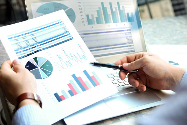 istock Business man working and analyzing financial figures on a graphs on a laptop outside 818179460