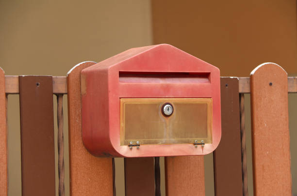 istock Red mailbox with brown wood fence. 818208856