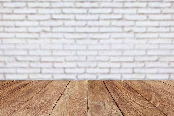 istock Wood table top on brick wall background 818234296