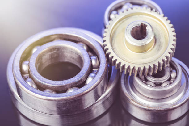 istock Group of various ball bearings and gears close up on nice blue background with reflections 818235814