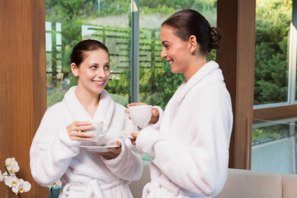 istock Smiling women in bathrobes having tea 818236208