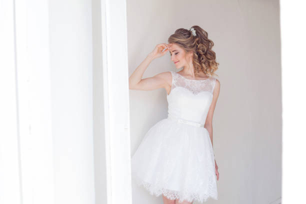 ładna dziewczyna w krótkiej białej sukni ślubnej - suknia ślubna zdjęcia i obrazy z banku zdjęć