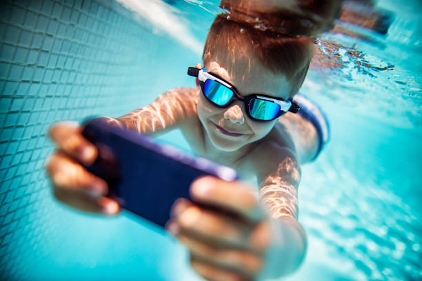 istock Little boy photographing underwater 818254306