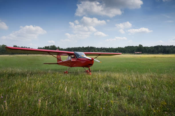 istock Light aircraft. Light red school airplane on airport grass 818269346