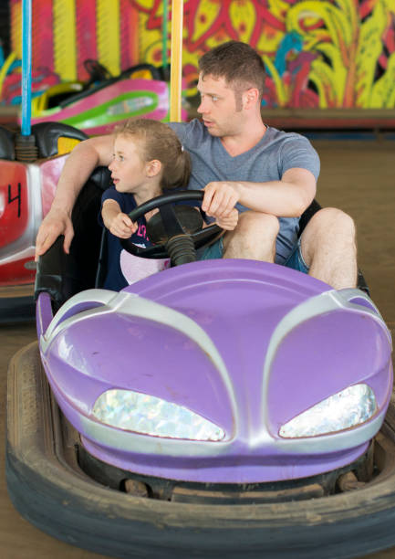 istock Father and daughter having fun on bumper car in amusement park. 818291358