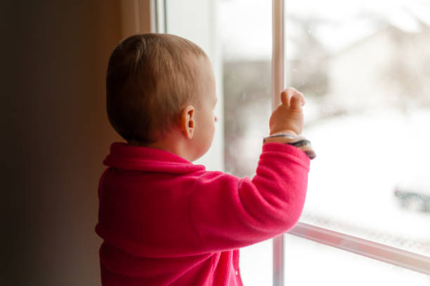 istock girl looking trough the window 818291714