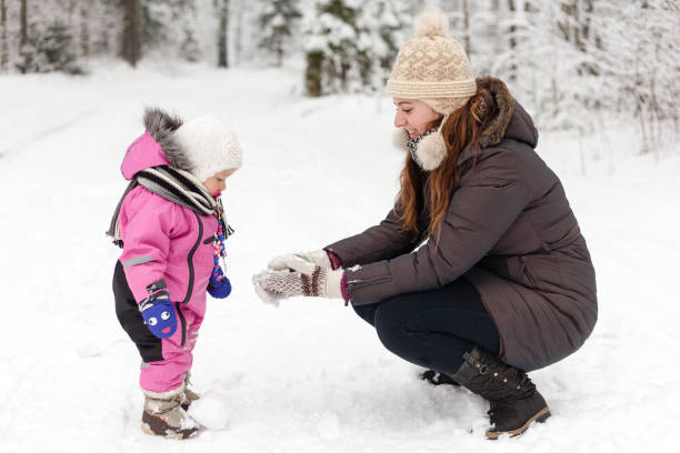 istock girl is playing with snow with mother 818291728