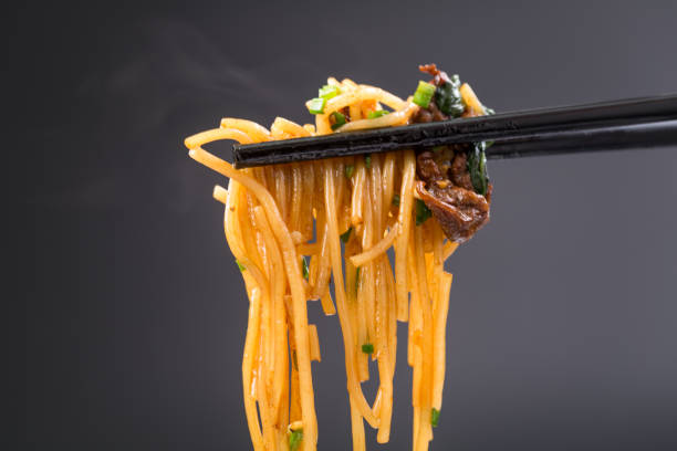 黒の背景で炒めライス ヌードル - chopsticks stir fried vegetable beef ストックフォトと画像