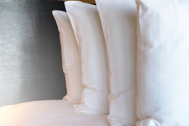 istock stacking of white pillows on bed - Close up 818336866