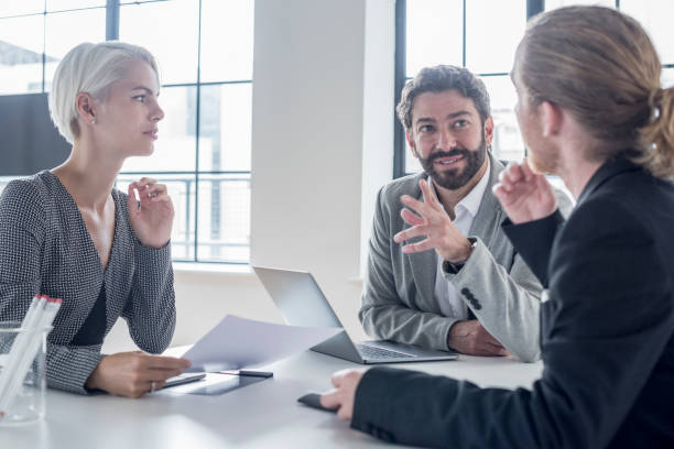istock Three business colleagues having meeting in office with laptop 818340926