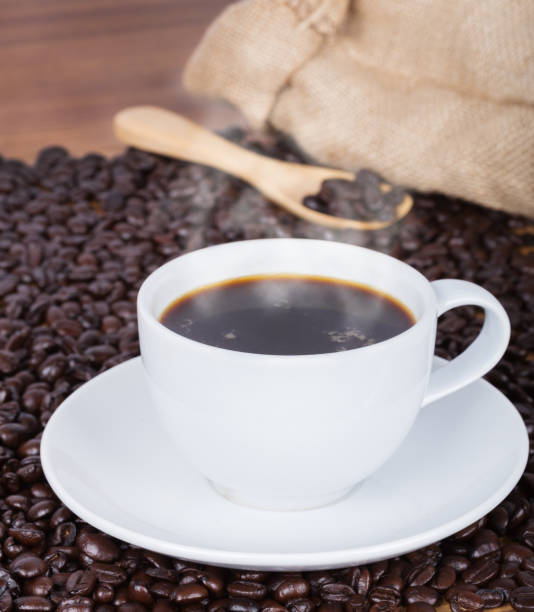 istock Coffee cup and beans on wooden background 818357946