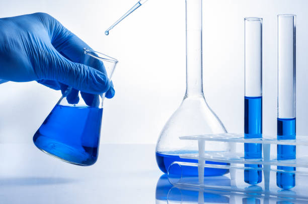 istock Laboratory beaker in analyst's hand in plastic glove. 818358466
