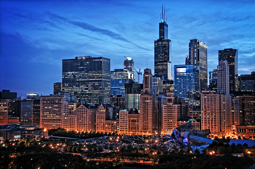 Chicago lakefront skyline cityscape at night by millenium park with a dramatic cloudy sky.