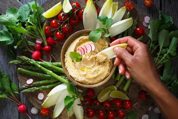 Plate of roasted radishes hummus with raw vegetables