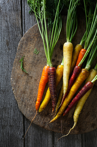 Colored carrots on a wood background