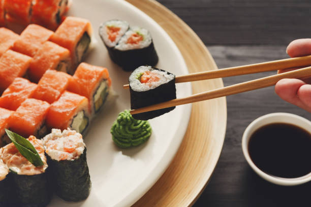 istock Eating sushi and rolls in japanese restaurant 818376666