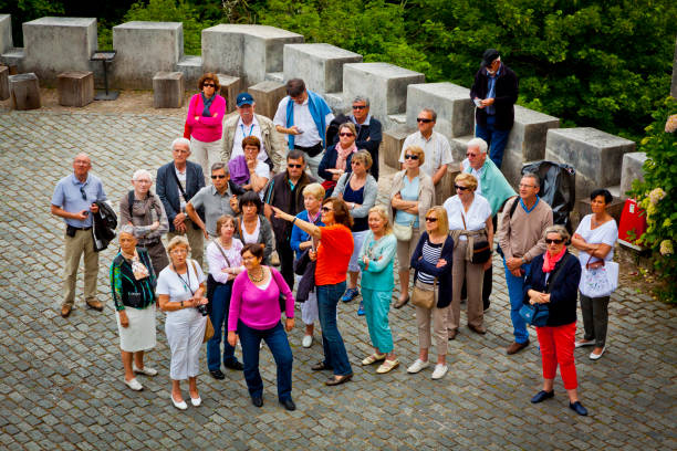grupo de turistas escuchando la guía de - town of progress fotografías e imágenes de stock