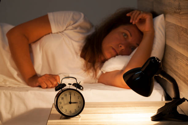Woman lying in bed suffering from insomnia