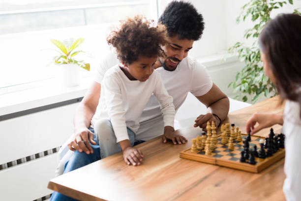 istock Happy family playing chess together at home 818390124