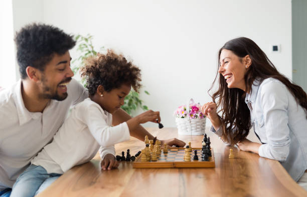 istock Happy family playing chess together at home 818390512