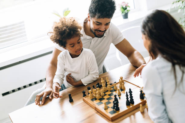 istock Happy family playing chess together at home 818390846