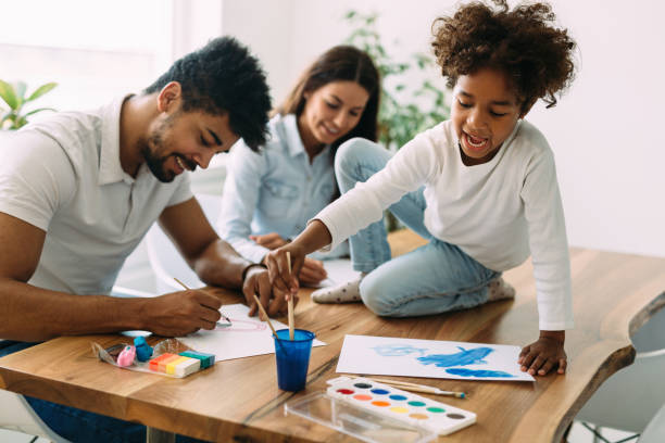 istock Mother and father drawing together with their child 818398380