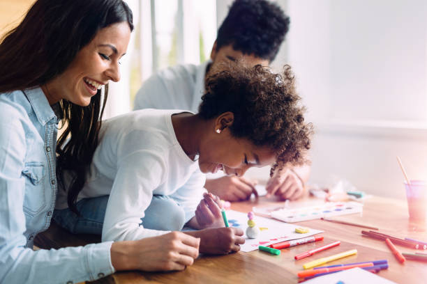 istock Mother and father drawing together with their child 818399092