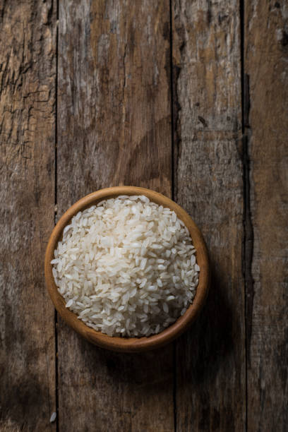 istock raw white rice in a bowl - top view 818429086