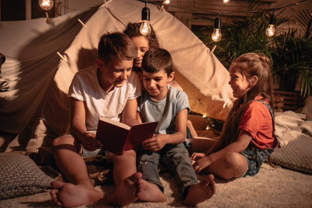 istock multicultural group of smiling children reading book at home 818430222