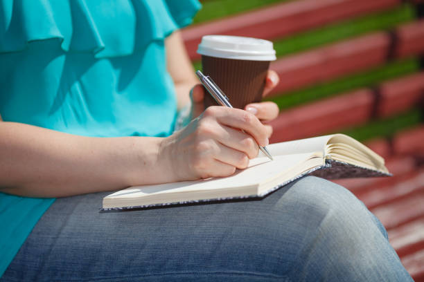 istock woman studying and writing in a park 818438052