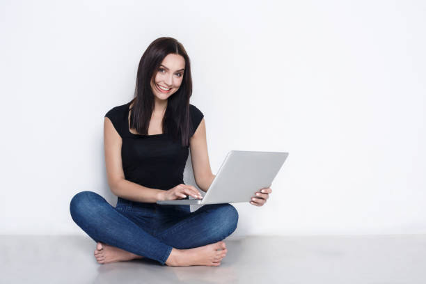 istock Woman using laptop sitting on the studio floor 818439150
