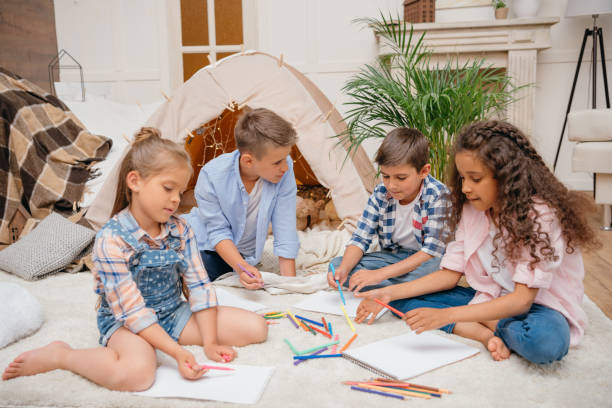 multiethnic group of kids drawing pictures with pencils at home