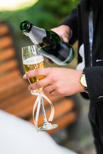istock Man pours champagne into glass 818446536