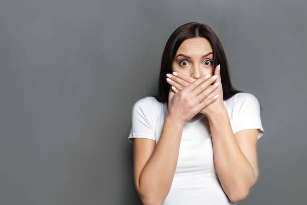 istock Scared woman covering mouth with hands 818455212