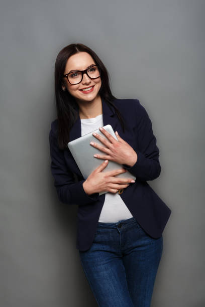 istock Happy woman with tablet on gray background 818456276