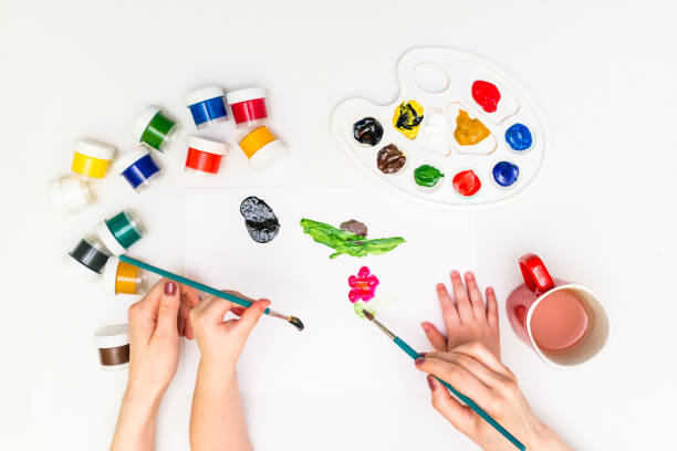 istock Child's hands painting a flower 818456428