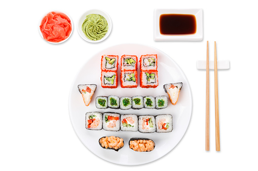 Japanese food restaurant, colorful rolls, gunkan and sushi platter. Set with chopsticks, soy sauce, ginger and wasabi. Top view on white background