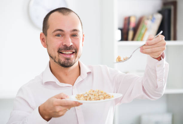 istock Positive young man eating porridge 818498398